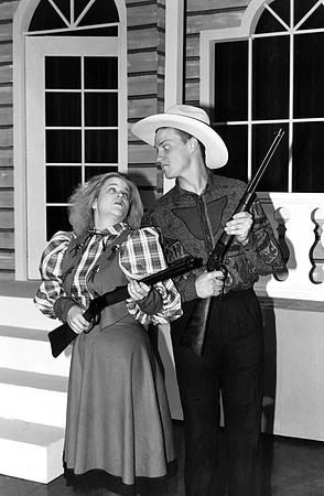 A man and a woman holding rifles