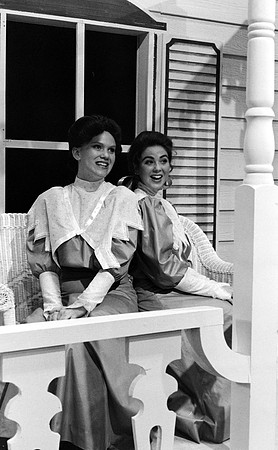 Two ladies sitting on a porch.