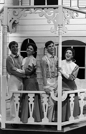 Two couples standing on a porch.