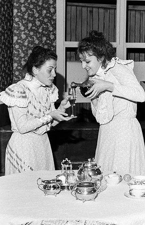 Maids pooring wine in a cup.