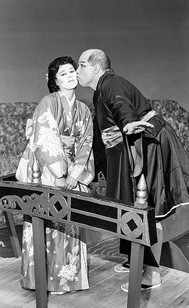 Chinees man kissing chinees woman on the cheek.