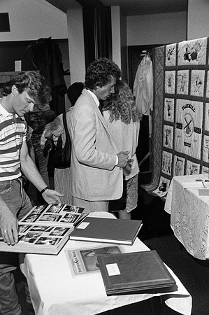 Playmill reunion participants looking at a photo album.