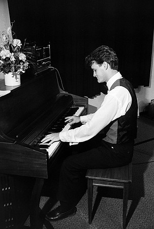 Man playing the piano at Playmill reunion.