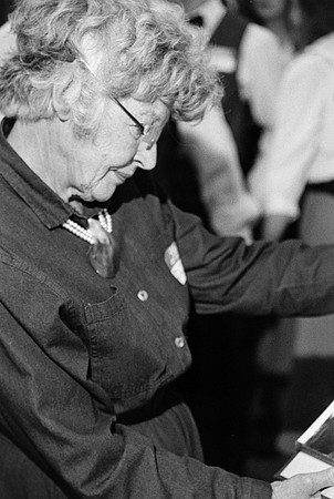 A woman looking at a photo album at the Playmill reunion.