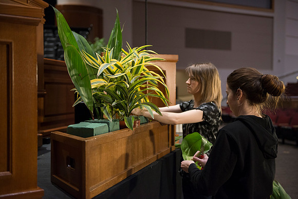 Floral Design students, Lauren Smith and Margaret Setterstrom create a beautiful floral arrangement in front of the podium for devotional.
