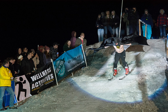 Students make a run down a snowy slope and across a pond of water in the annual event of Pond Skimming.