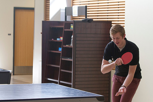 A student gets ready to serve during an intense match of ping pong.