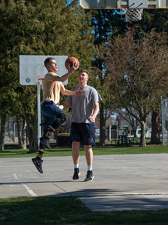 Jacob Kaiser (in yellow) playing basketball, one on one with Jacob Madsen at Smith Park in Rexburg, Idaho.