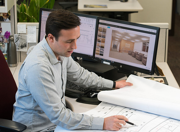 Sterling Kreutzer, a Construction Management major working with architectural drawings and 3D design at the University Operations Facility.