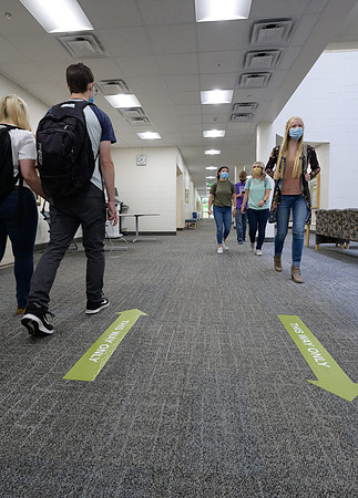 Student volunteers show the way to stay safe during this COVID 19 pandemic by social distancing, following pathway arrows and proper wearing of masks .