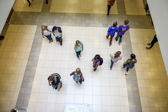 Student volunteers show the way to stay safe during this COVID 19 pandemic by social distancing, following pathway arrows and proper wearing of masks .