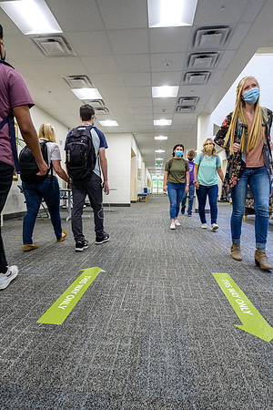 Student volunteers show the way to stay safe during this COVID 19 pandemic by social distancing, following pathway arrows and proper wearing of masks .