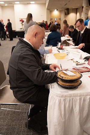 Employee writing a card at the Employee Christmas Pie Social.