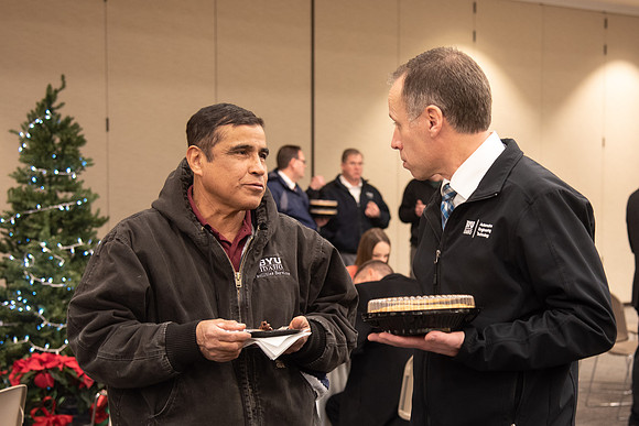 Employees socializing at the Employee Christmas Pie Social.