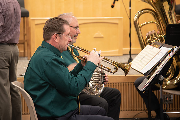 Entertainment at the Employee Christmas Pie Social. Men playing Christmas music on the trumpet.