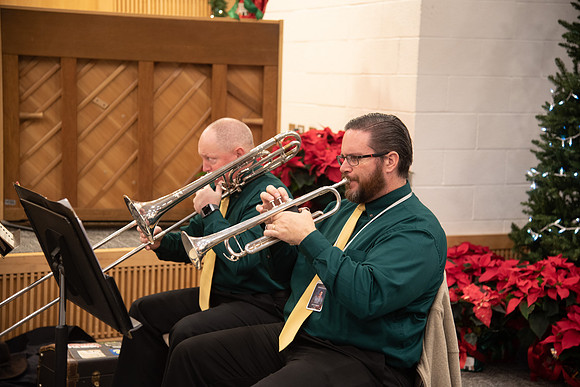 Entertainment at the Employee Christmas Pie Social. Men playing Christmas music on the trumpet and the trombone.