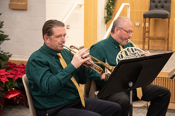 Entertainment at the Employee Christmas Pie Social. Men playing Christmas music on the trumpet and the french horn.