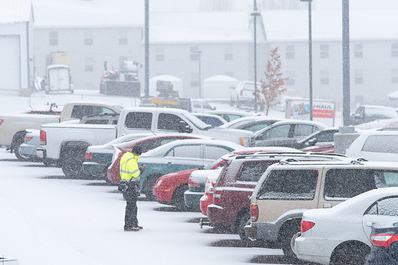 Fresh snow falling on campus of BYU-Idaho. Parking security checking parking permits.