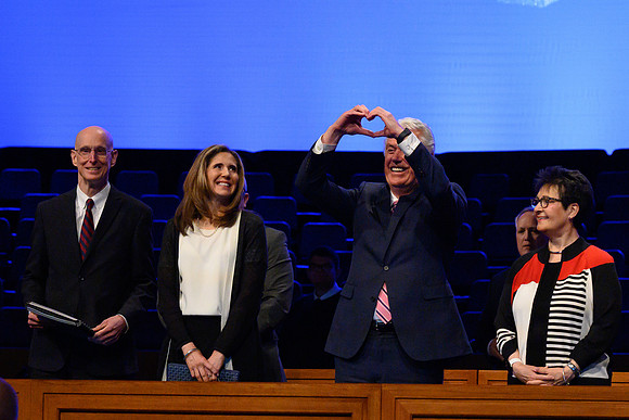 Elder and Sister Uchtdorg wave and welcome thousands of students to the devotional.
