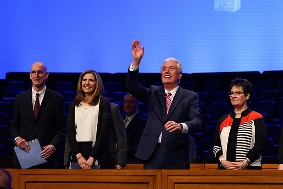 Elder and Sister Uchtdorg wave and welcome thousands of students to the devotional.