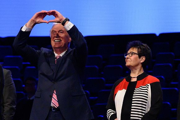 Elder and Sister Uchtdorg wave and welcome thousands of students to the devotional.
