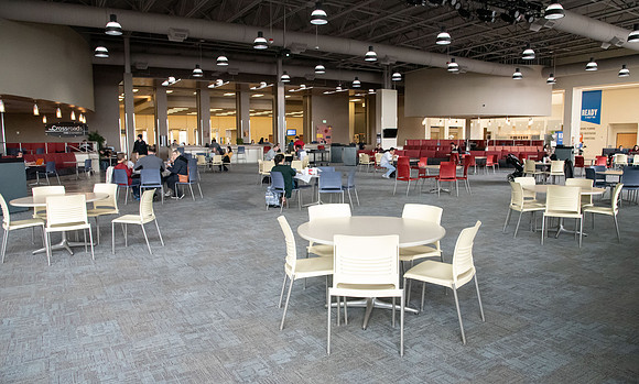 The Crossroads is practically empty with the COVID-19 pandemic. Tables and chairs stacked up as other tables are separated to be six feet apart.