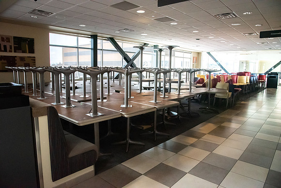 The Crossroads is practically empty with the COVID-19 pandemic. Tables and chairs stacked up as other tables are separated to be six feet apart.