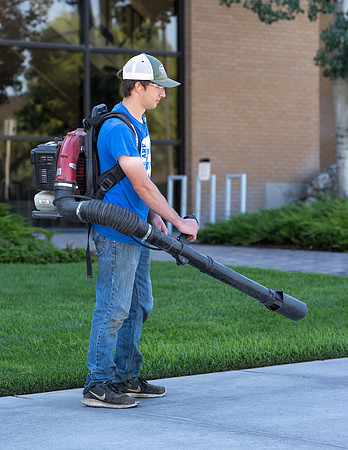 Blowing the sidewalks clean.