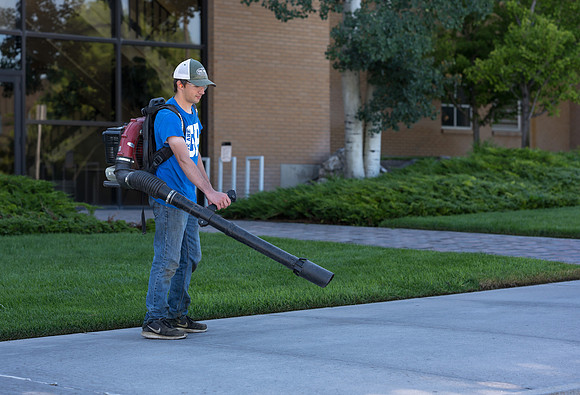 Blowing the sidewalks clean.