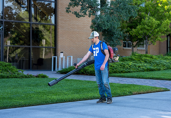 Blowing the sidewalks clean.