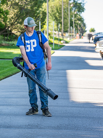 Blowing the sidewalks clean.