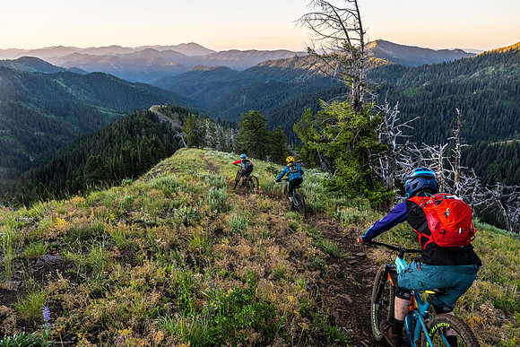 Mountain bikers riding the upper section of Piney Peak in the Big Hole Mountains at sunrise.
