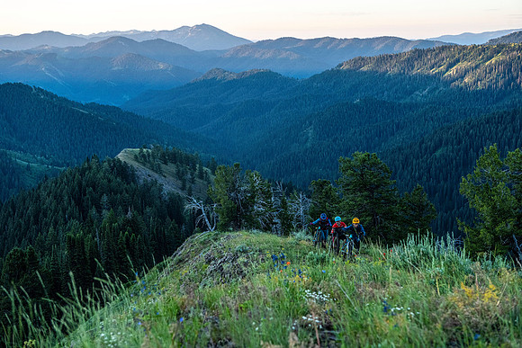 Mountain bikers riding the upper section of Piney Peak in the Big Hole Mountains at sunrise.