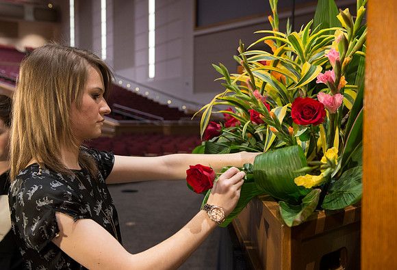 Floral Design students, Lauren Smith and Margaret Setterstrom create a beautiful floral arrangement in front of the podium for devotional.