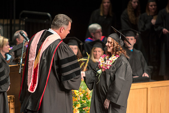 Faculty members hand degrees to and congratualate graduates of the College of Performing and Visual Arts.