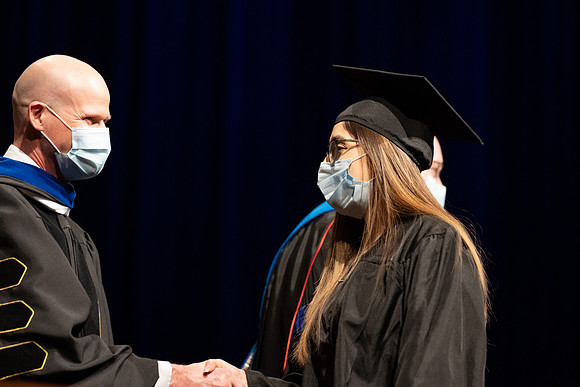Combined Convocation for the College of Business & Communication and also the College of Physical Sciences & Engineering. Graduates receive their diploma covers.