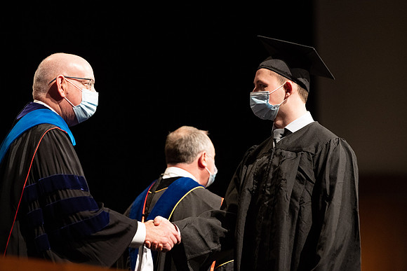 Combined Convocation for the College of Business & Communication and also the College of Physical Sciences & Engineering. Graduates receive their diploma covers.