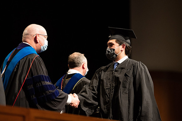 Combined Convocation for the College of Business & Communication and also the College of Physical Sciences & Engineering. Graduates receive their diploma covers.