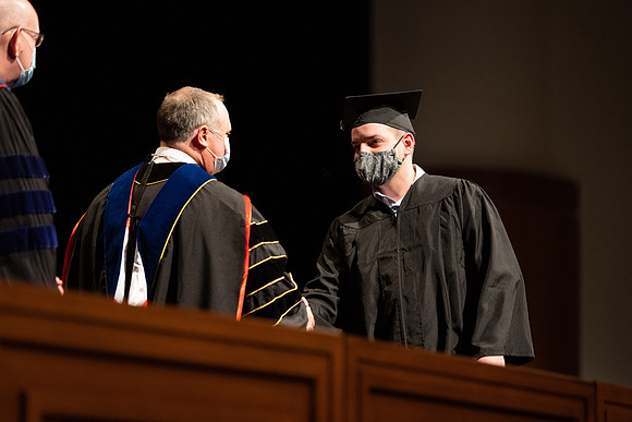 Combined Convocation for the College of Business & Communication and also the College of Physical Sciences & Engineering. Graduates receive their diploma covers.