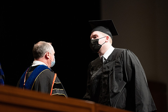 Combined Convocation for the College of Business & Communication and also the College of Physical Sciences & Engineering. Graduates receive their diploma covers.