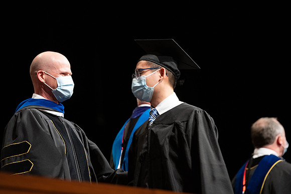 Combined Convocation for the College of Business & Communication and also the College of Physical Sciences & Engineering. Graduates receive their diploma covers.