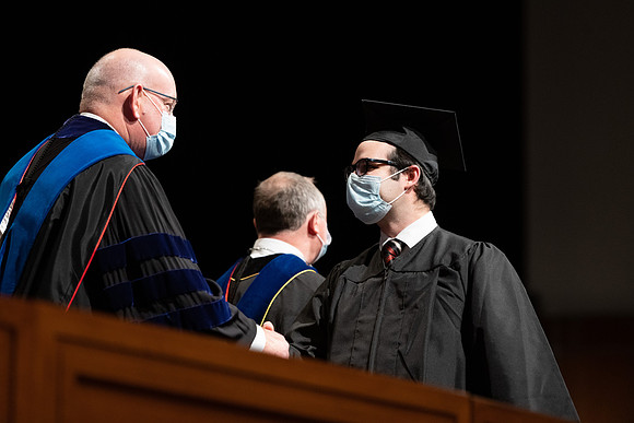 Combined Convocation for the College of Business & Communication and also the College of Physical Sciences & Engineering. Graduates receive their diploma covers.