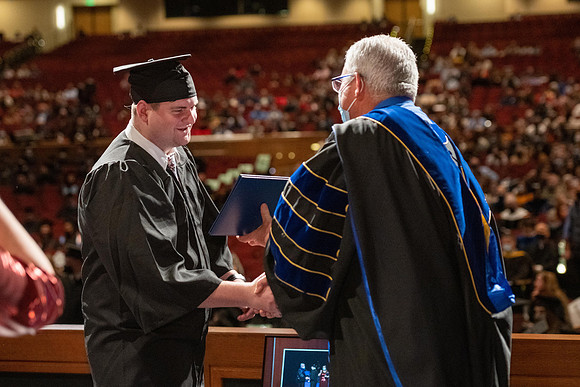 Combined Convocation for the College of Business & Communication and also the College of Physical Sciences & Engineering. Graduates receive their diploma covers.