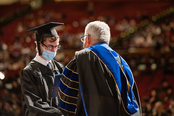 Combined Convocation for the College of Business & Communication and also the College of Physical Sciences & Engineering. Graduates receive their diploma covers.