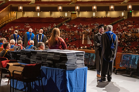 Combined Convocation for the College of Business & Communication and also the College of Physical Sciences & Engineering. Graduates receive their diploma covers.