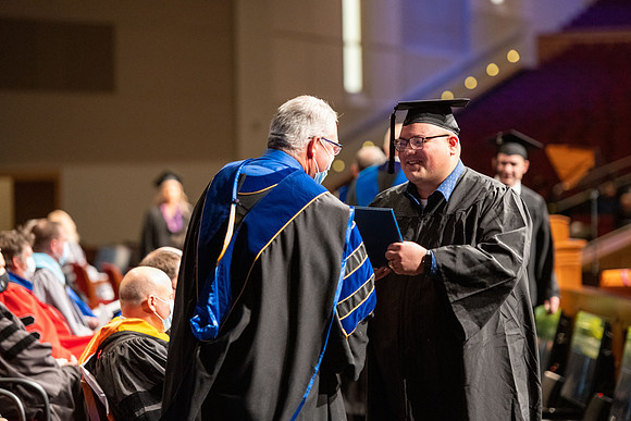 Combined Convocation for the College of Business & Communication and also the College of Physical Sciences & Engineering. Graduates receive their diploma covers.