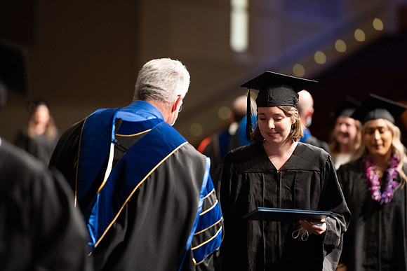 Combined Convocation for the College of Business & Communication and also the College of Physical Sciences & Engineering. Graduates receive their diploma covers.