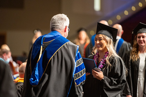 Combined Convocation for the College of Business & Communication and also the College of Physical Sciences & Engineering. Graduates receive their diploma covers.