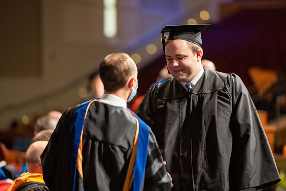 Combined Convocation for the College of Business & Communication and also the College of Physical Sciences & Engineering. Graduates receive their diploma covers.