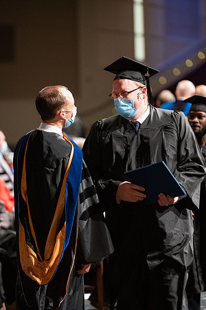 Combined Convocation for the College of Business & Communication and also the College of Physical Sciences & Engineering. Graduates receive their diploma covers.
